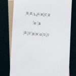 A simple card displaying the message 'Balance or Burnout' emphasizing mental health and stress management.